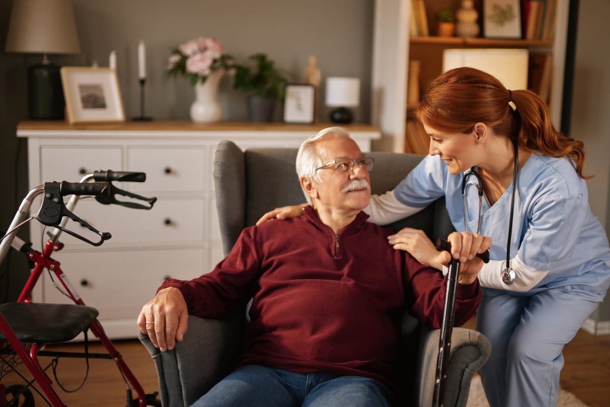 Home healthcare nurse assisting a senior man