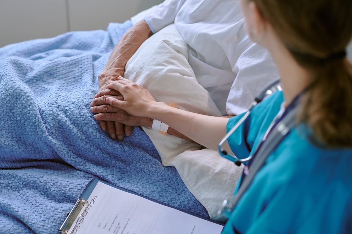 Nurse comforting senior patient in clinical setting